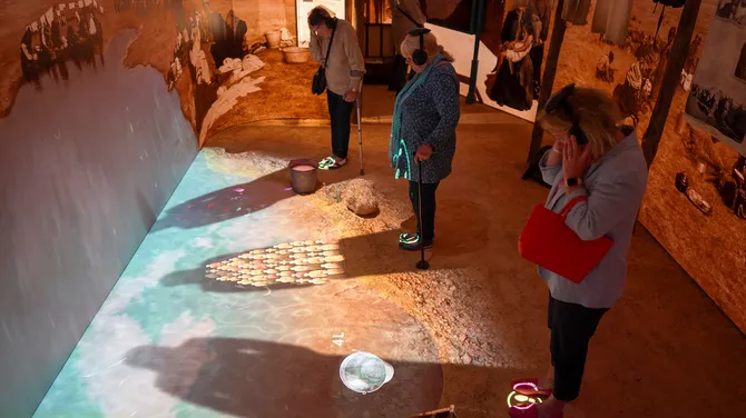 A space that responds to you: when you step up to the murky pond, your shadow reveals stories about rations and water in the camps during the War.