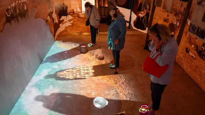 A space that responds to you: when you step up to the murky pond, your shadow reveals stories about rations and water in the camps during the War.